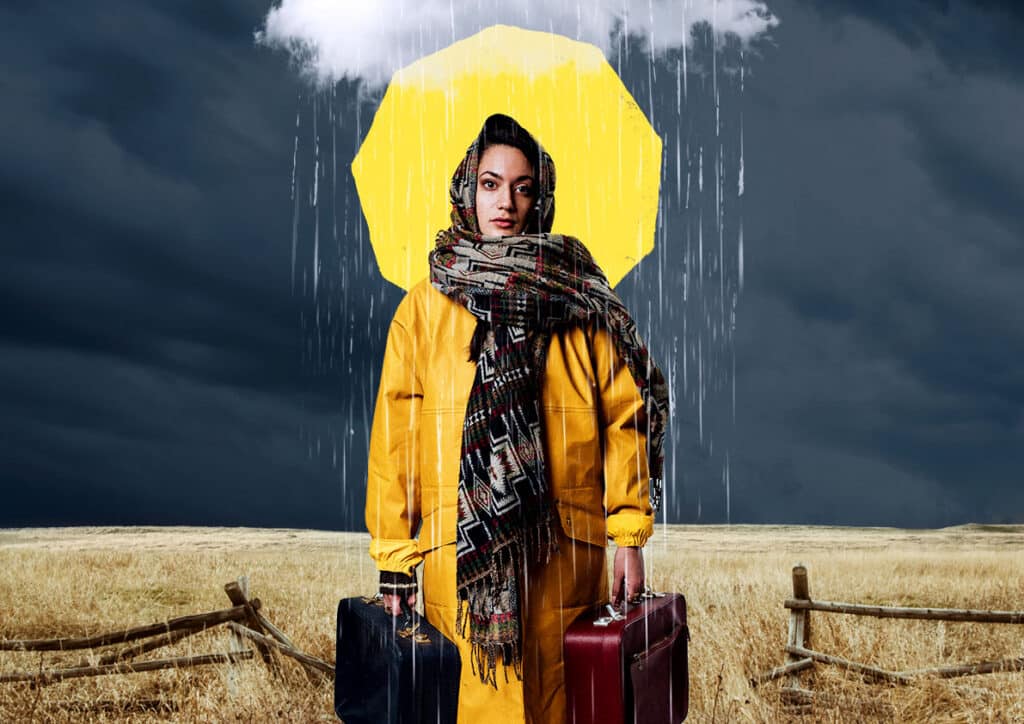 Woman stands centre looking directly out carrying two hand-held suitcases, wearing a mustard anorak and a patterned scarf draped over her head and shoulders. She is stood in a wheatfield with wooden fences, an overcast sky. Behind her head is an illustration of a yellow sun, with rain and clouds.