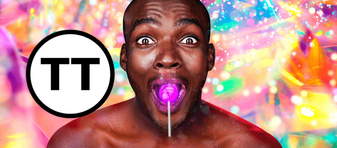 Touch Tour symbol. Close up of a smiling, wide-eyed, bare-chested black man, with a glowing purple lollipop in his mouth. The background behind him is bright, multi-coloured and full of sparkles